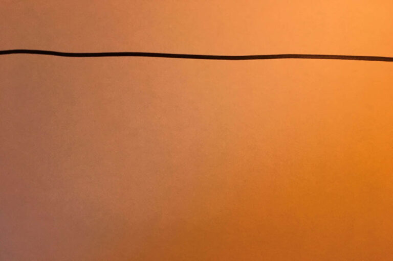 horizontal wobbly brown pen line on orange paper